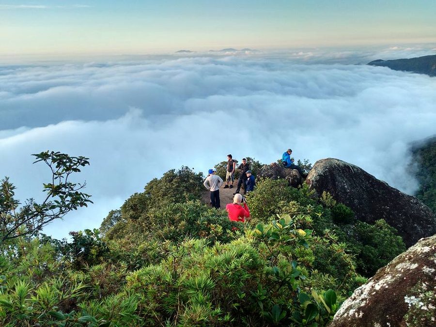 Grupo no alto do Pico do Corcovado, acima de um mar de nuvens