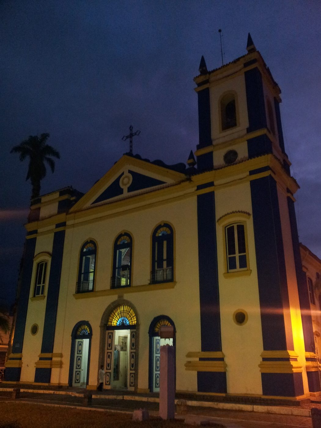 Fachada azul e amarela da Igreja Matriz de Ubatuba iluminada à noite