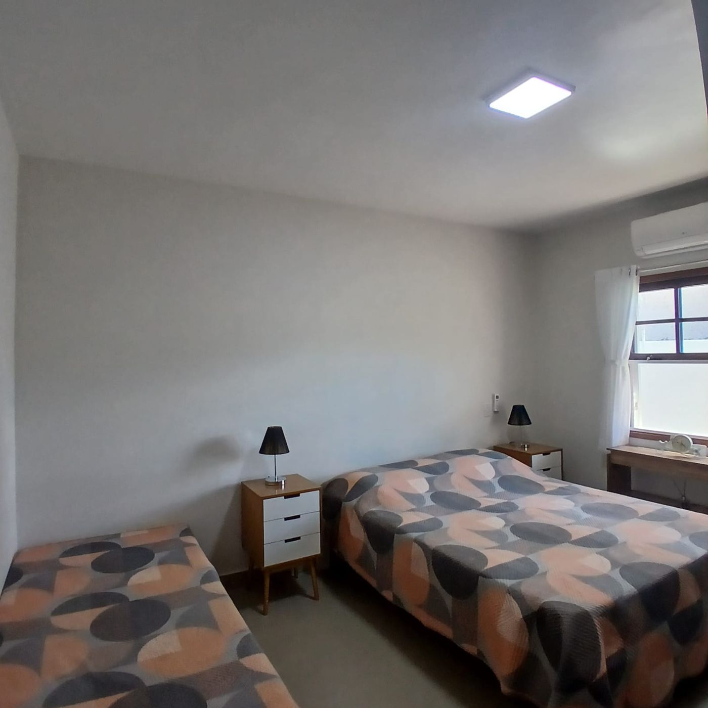 Quarto com cama de casal, cama de solteiro e ar-condicionado